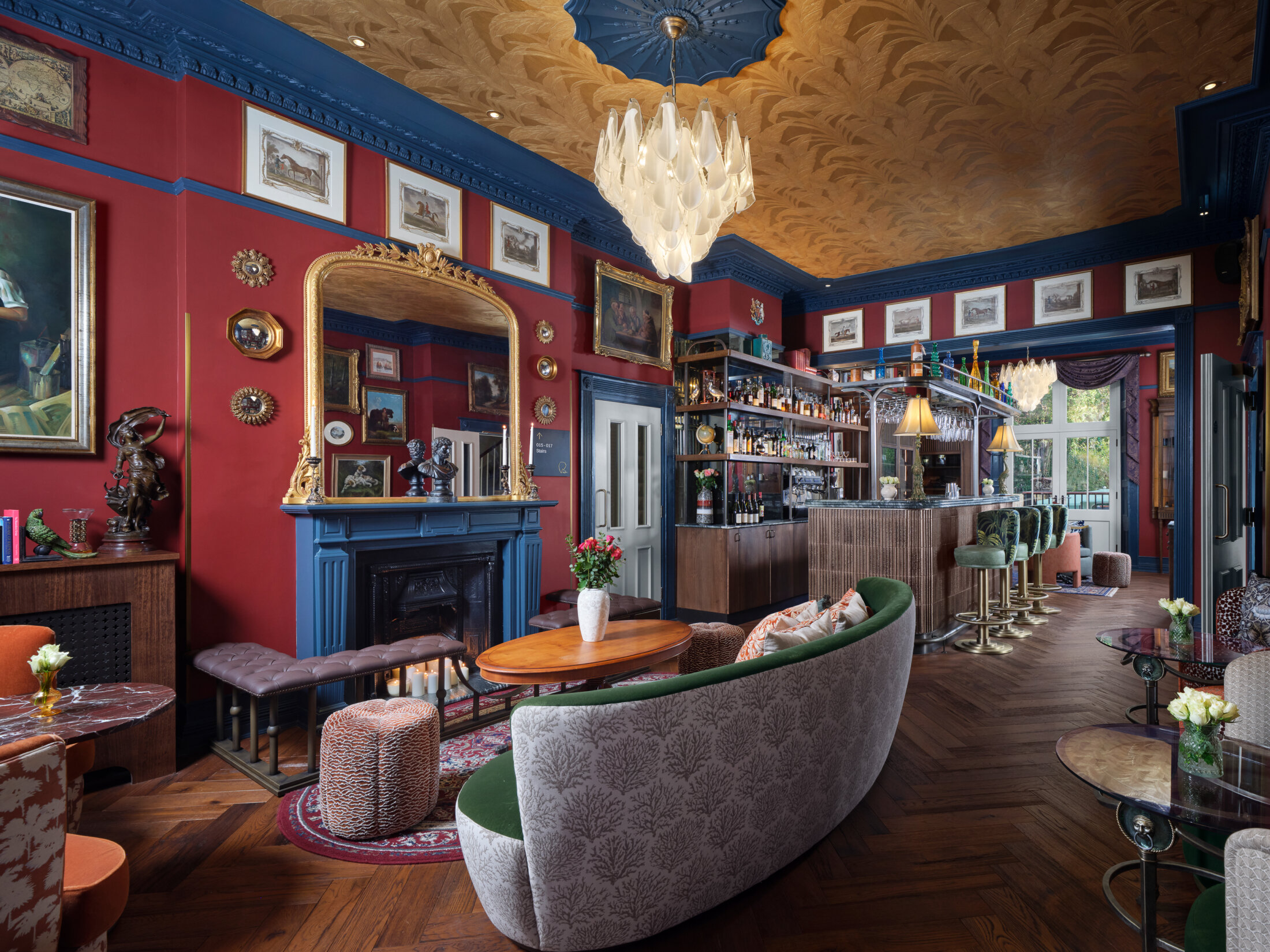 Ottie's salon at bertrand's townhouse with large green sofa, burgundy and blue walls