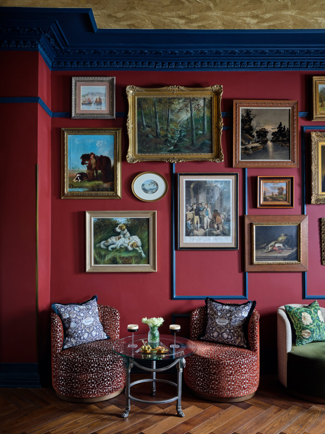 Ottie's salon at bertrand's townhouse with tub chairs and ornate frames with animals, and landscapes