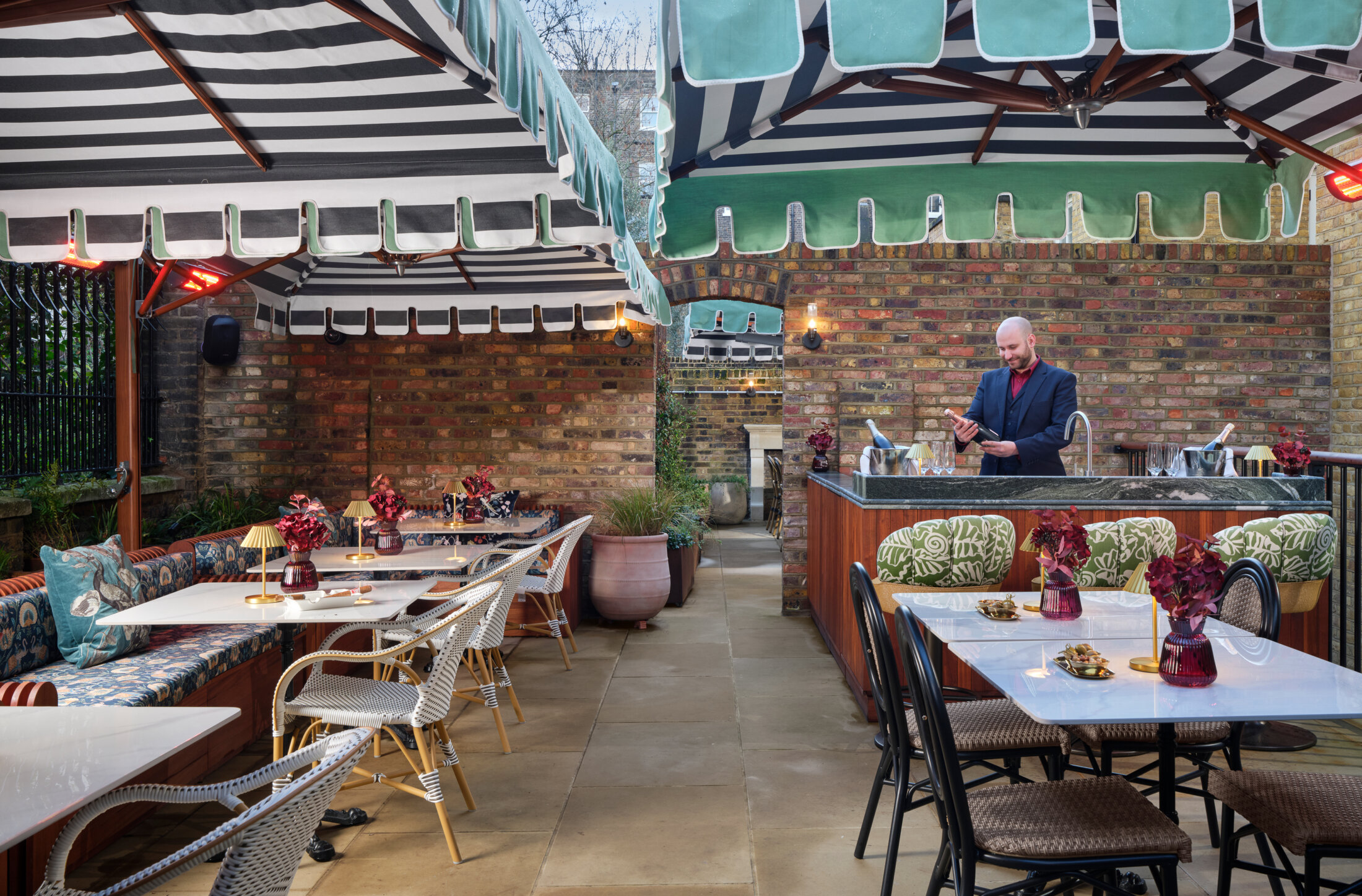 Outdoor terrace at bertrand's townhouse with bartender opening champagne