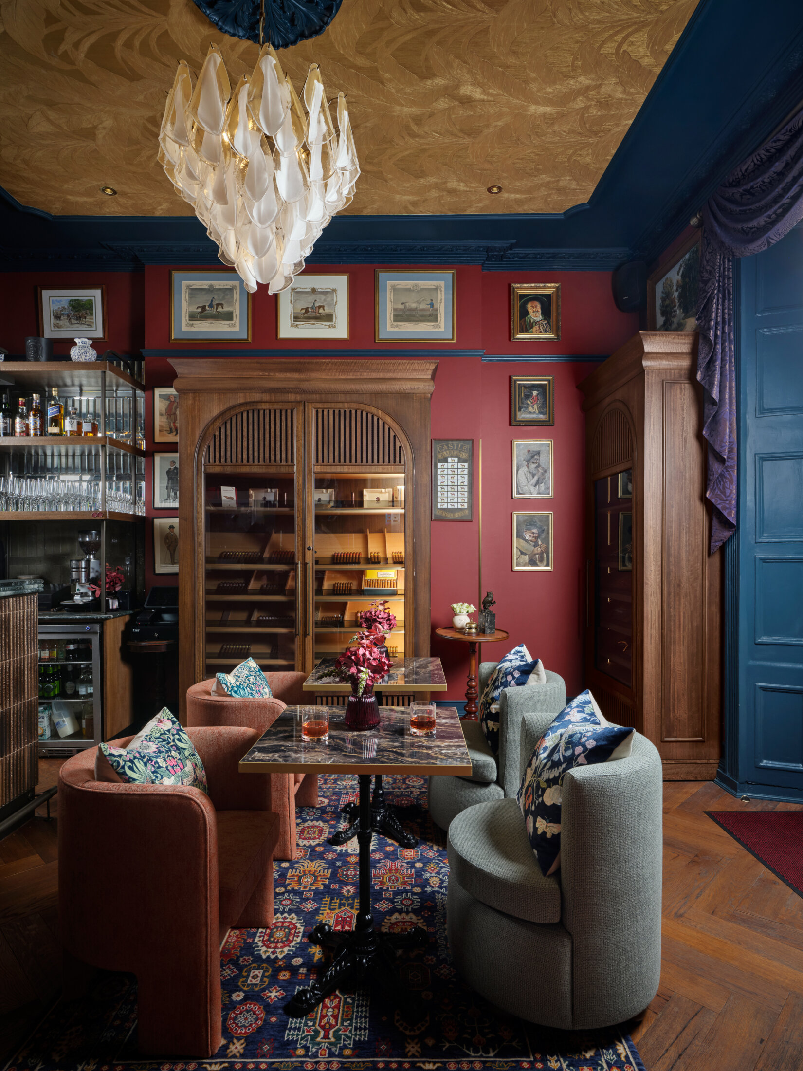 ottie's salon at bertrand's townhouse with large chairs, glasses of whiskey and the cigar cabinet