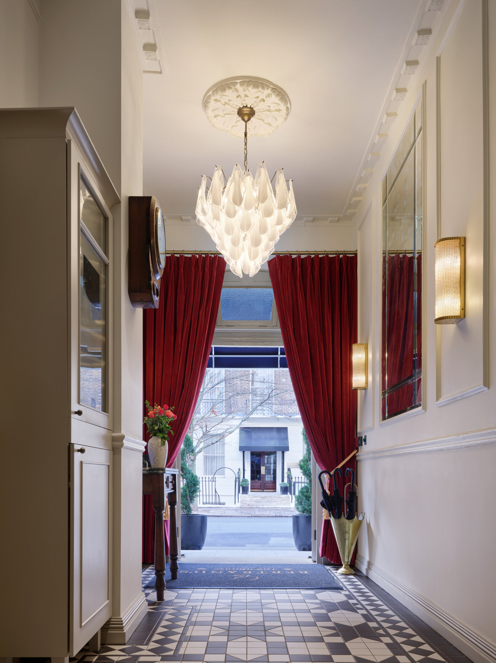 the entry way to bertrand's townhouse with red luxury curtains