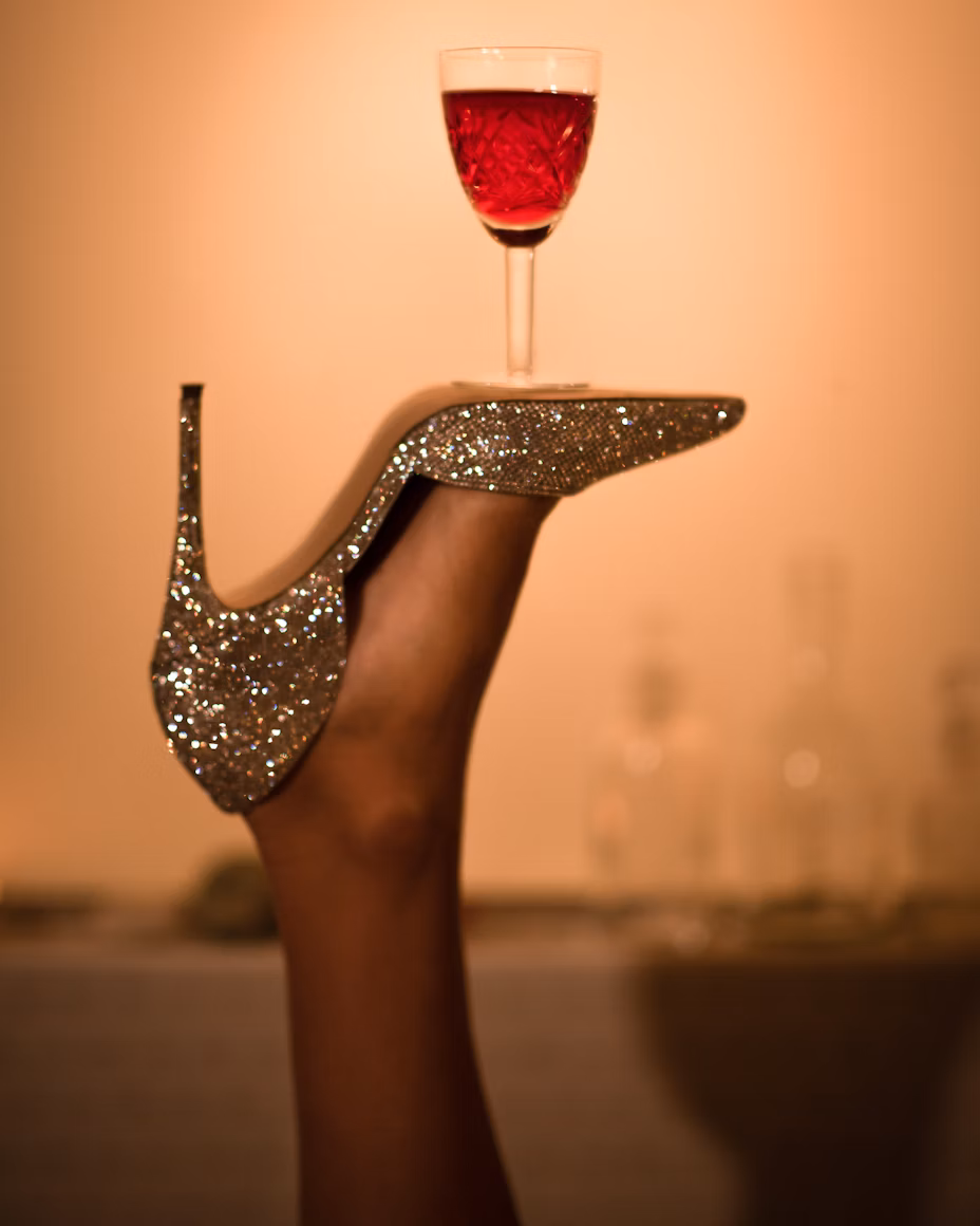 womans shoe upside down with drink balancing