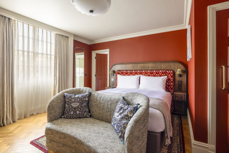 large hotel bedroom with dark red walls