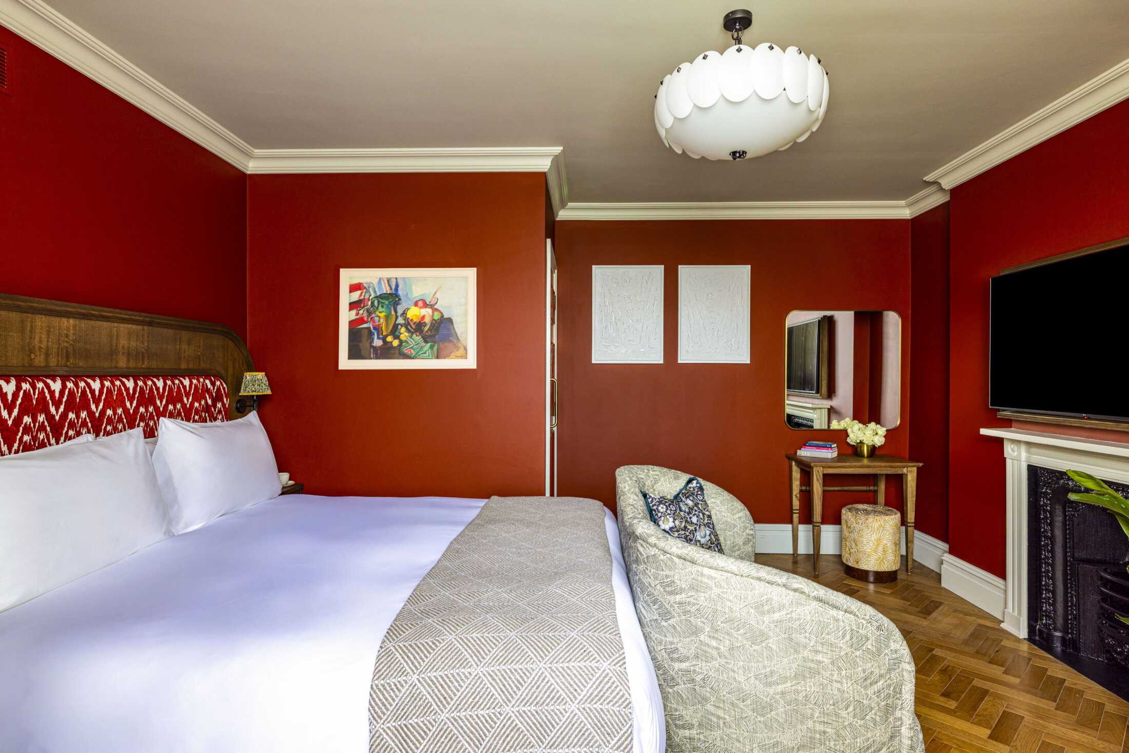 large hotel bedroom with dark red walls