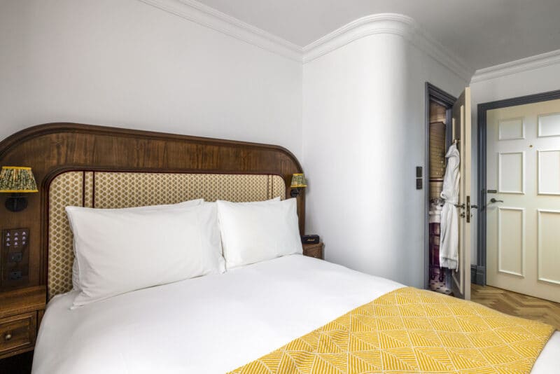 double hotel bedroom with yellow runner on bed