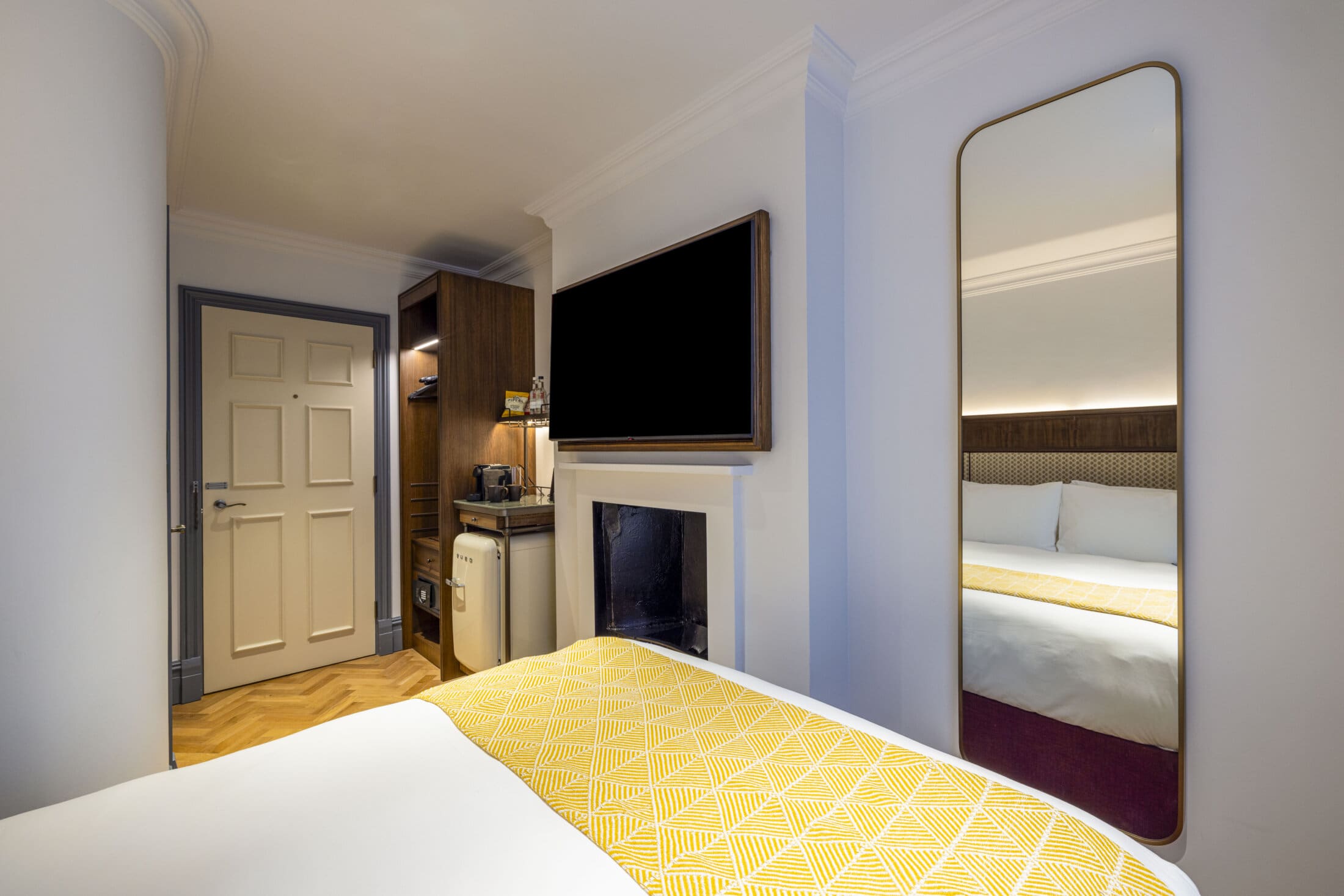 double hotel bedroom with yellow runner on bed