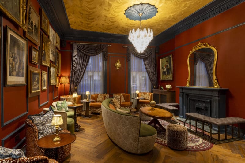 ottie's salon in bertrands townhouse with dark red walls and gold features