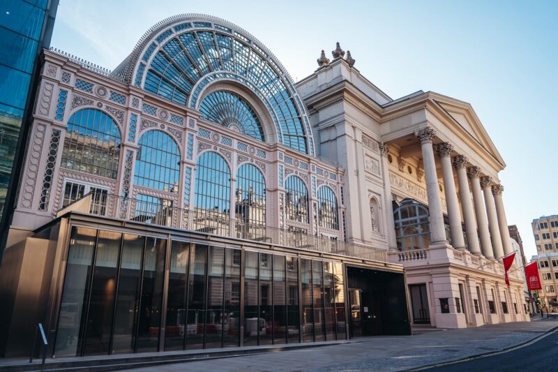 The grand building home to the Royal Ballet and Opera, beautifully designed with lots of windows in an arch shape.