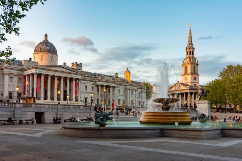 Trafalgar Square, with the National Portrait Gallery and fountain on a bright late afternoon.